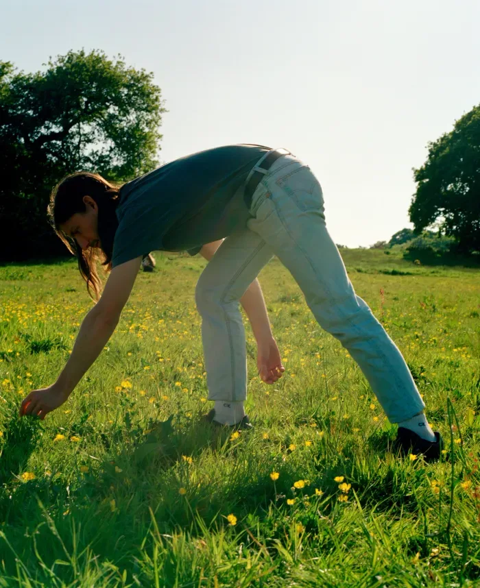 A researcher picking a flower in a meadow